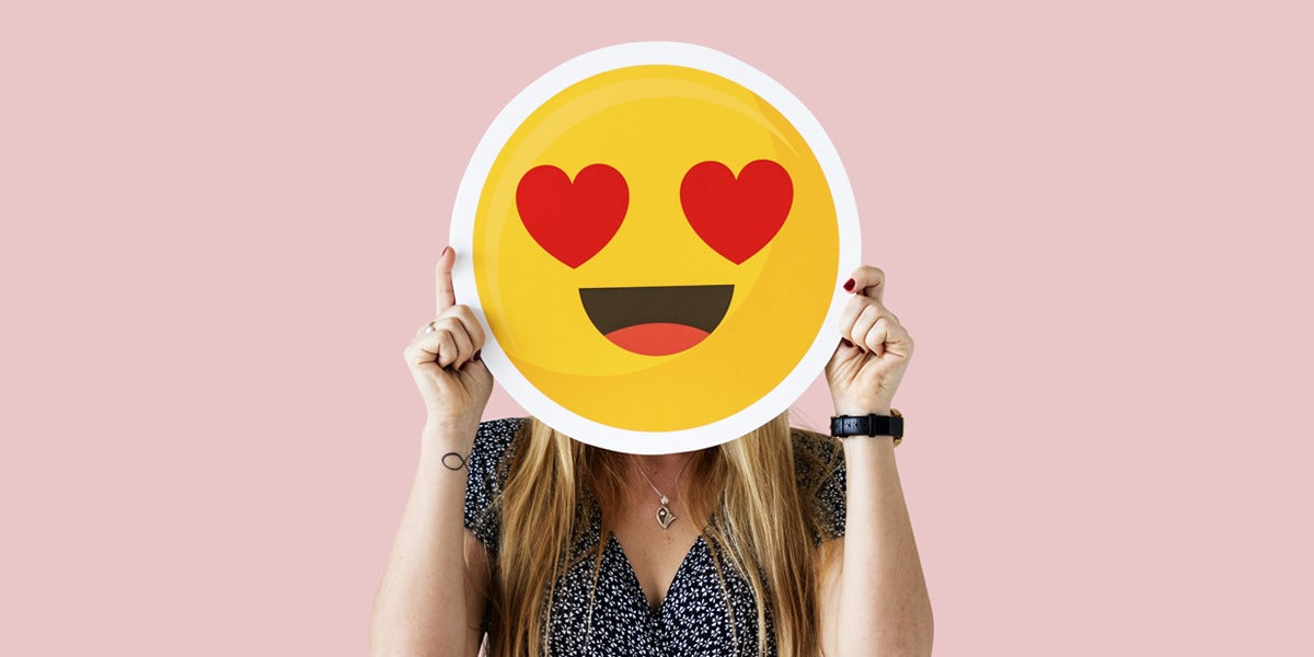 Lady covering her face with a heart eye happy emoji face