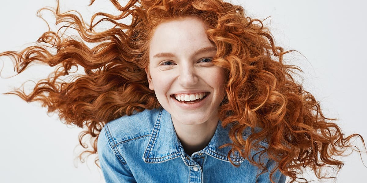 Lady smiling with glowing, healthy hair